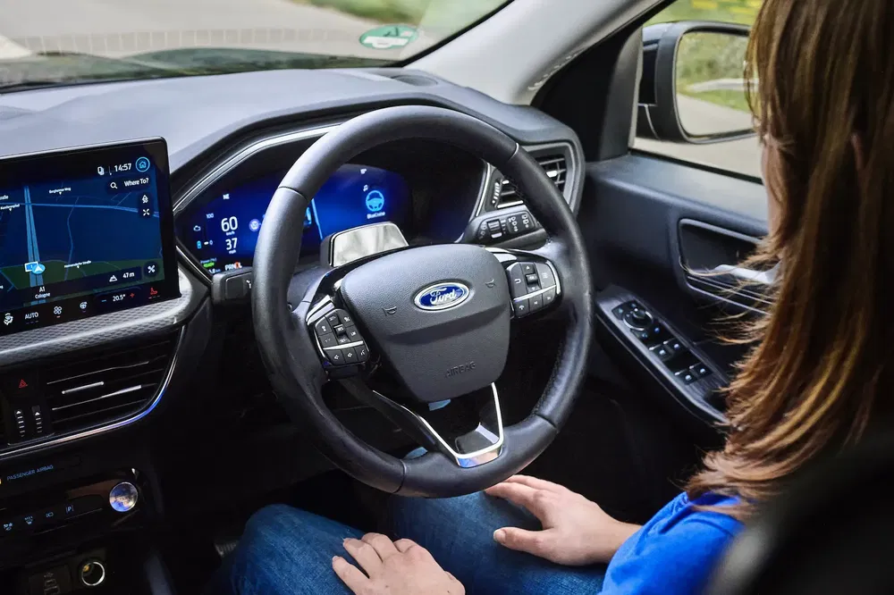 {"fr":"Intérieur Ford moderne avec volant, tableau de bord numérique et écran de navigation visible.","nl":"Moderne Ford-interieur met stuur, digitaal dashboard en zichtbaar navigatiescherm."}