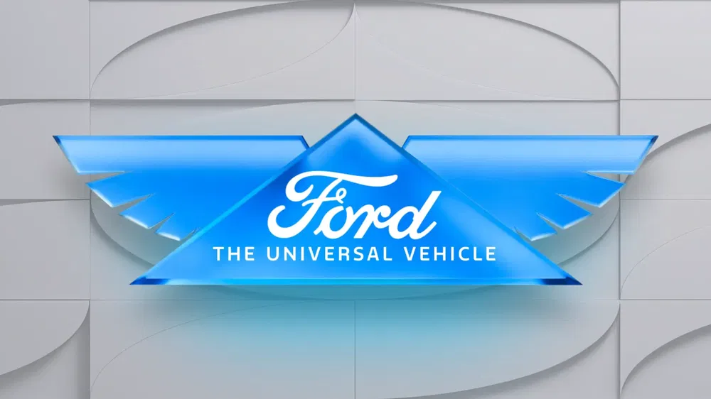 {"fr":"Logo Ford avec ailes bleues et slogan 'The Universal Vehicle' sur fond texturé gris.","nl":"Ford-logo met blauwe vleugels en slogan 'The Universal Vehicle' op grijze achtergrond."}