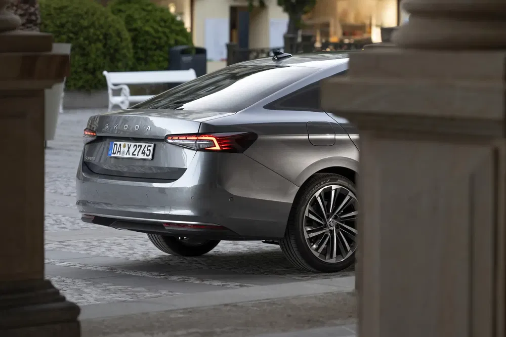 Vue arrière d'une Skoda Superb grise stationnée en milieu urbain élégant.