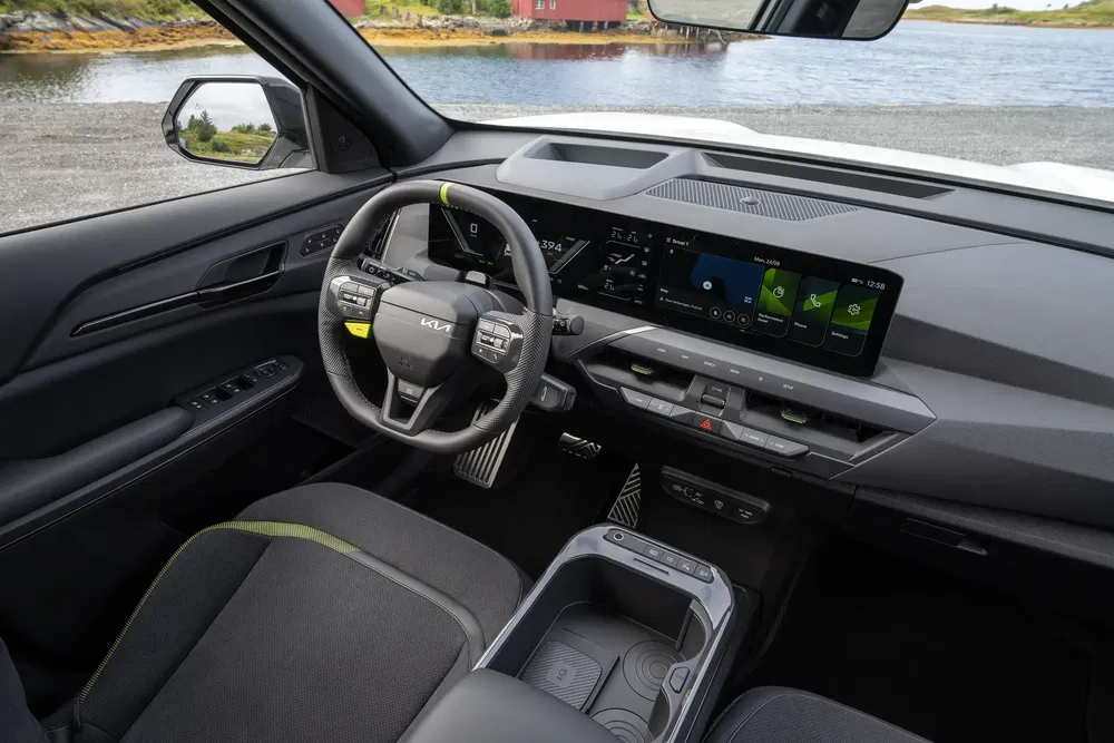 Intérieur high-tech du Kia EV9 avec écran tactile panoramique et volant moderne.