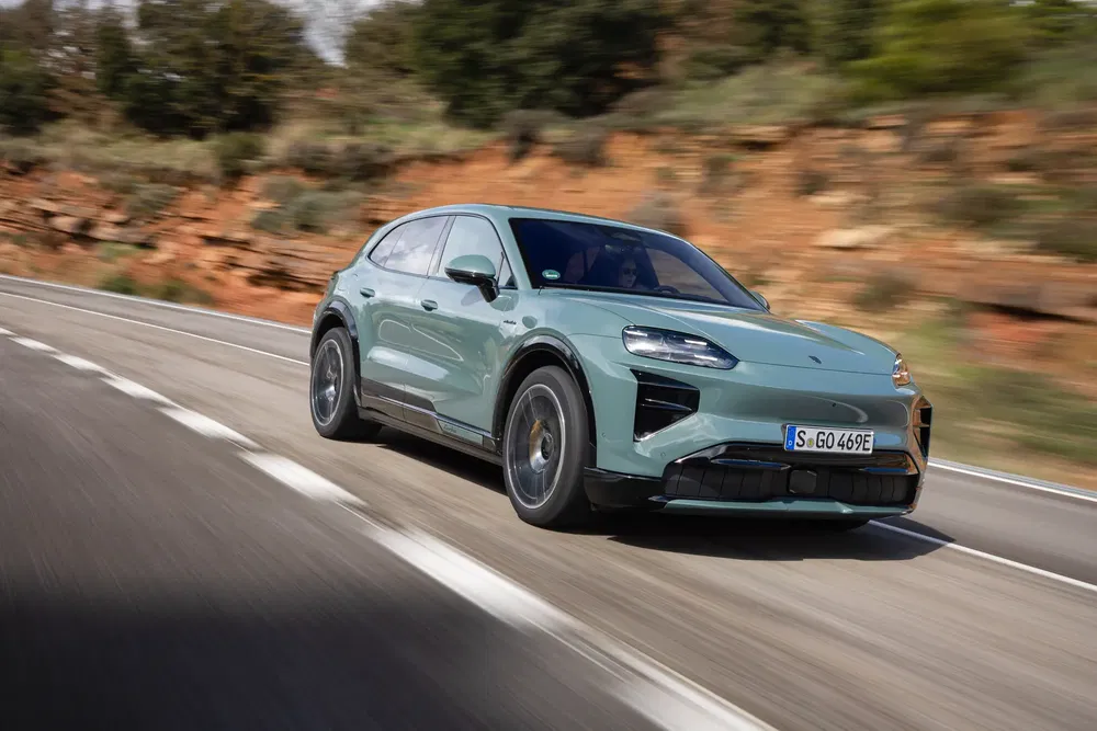 {"fr":"Porsche Macan électrique vert roulant sur une route sinueuse et panoramique.","nl":"Groene elektrische Porsche Macan rijdend op een kronkelende en schilderachtige weg."}