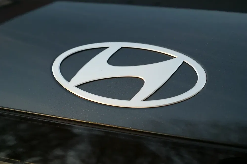 Logo Hyundai argenté sur fond noir brillant d'un véhicule.