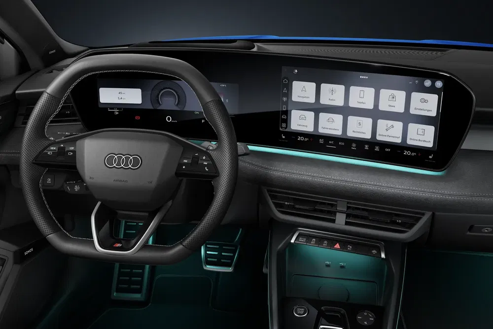 Intérieur de l'Audi Q6 e-tron avec tableau de bord numérique moderne et volant en cuir.