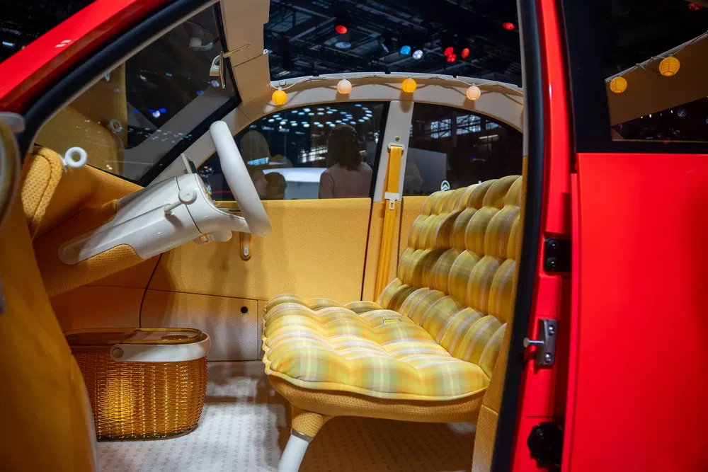 Kleurrijk, retro interieur van een moderne conceptauto met gestoffeerde zitplaatsen en uniek stuur.