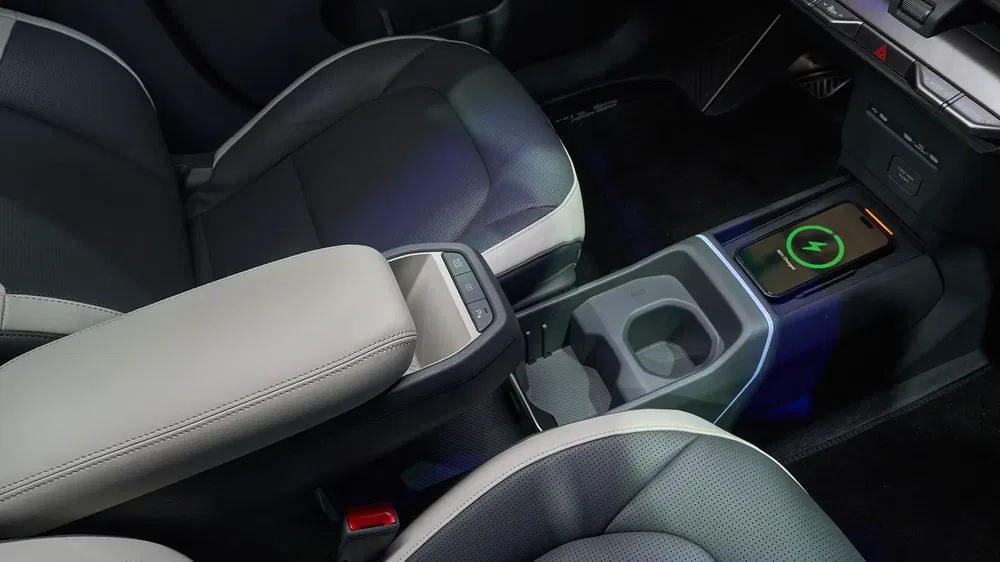 Intérieur de voiture moderne avec chargeur sans fil et sièges en cuir gris élégants.