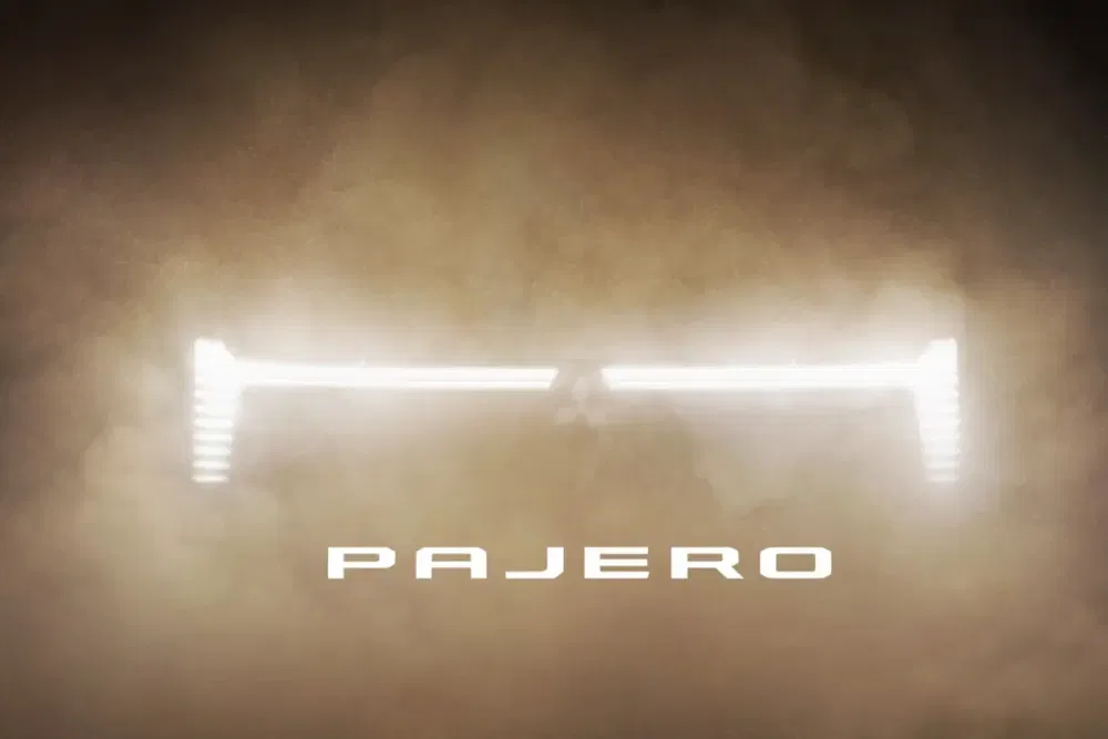 Koplampen van de Mitsubishi Pajero die door dichte mist schijnen.