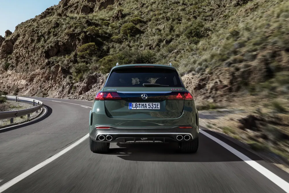 Mercedes-Benz op bochtige bergweg met rotsachtig en groen landschap.