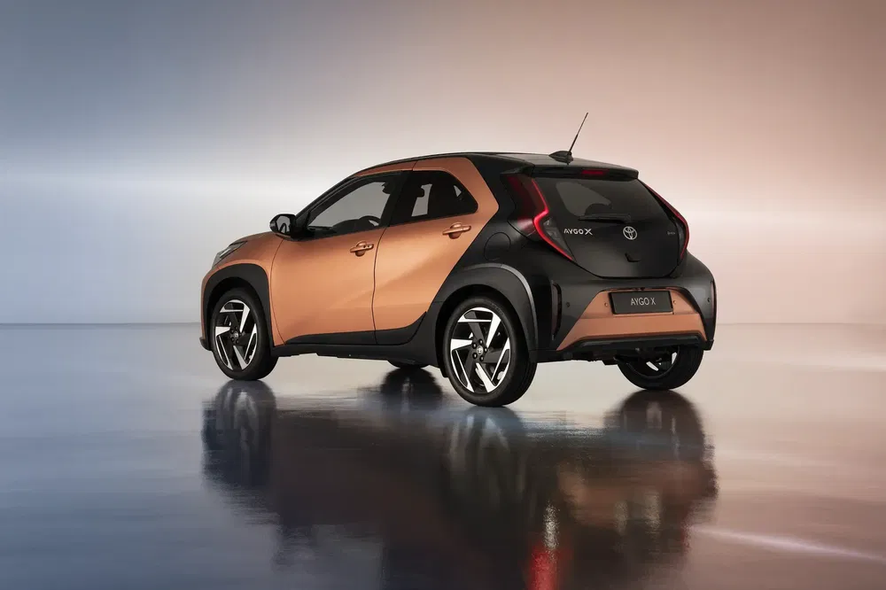 Toyota Aygo X 2023 op een reflecterende ondergrond, modern en compact ontwerp.