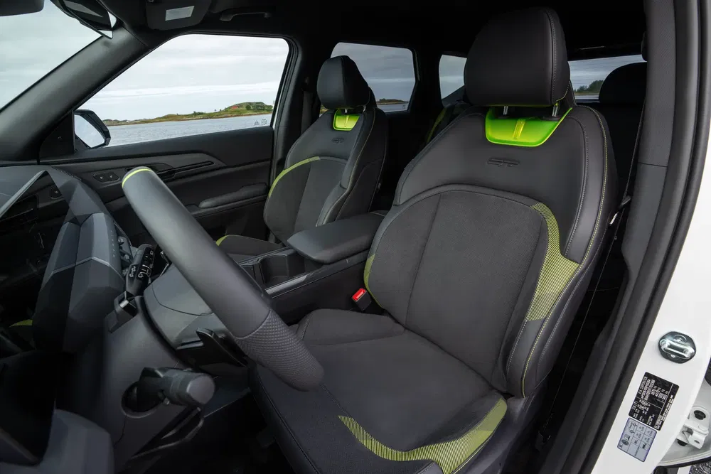 Intérieur de la Ford Ranger Raptor, sièges avant en tissu noir et accents verts.