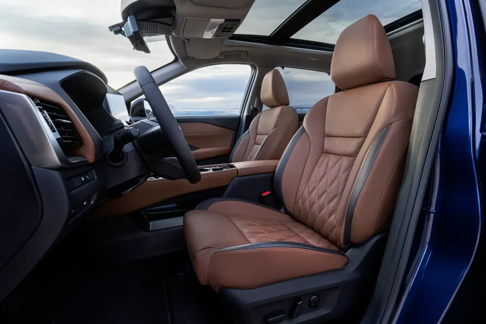 Nissan interieur met bruine lederen stoelen en panoramisch zonnedak.