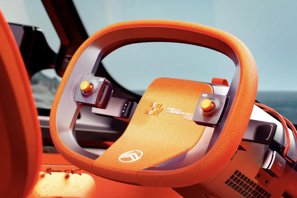 Volant concept orange Citroën, design futuriste, boutons de commande intégrés.