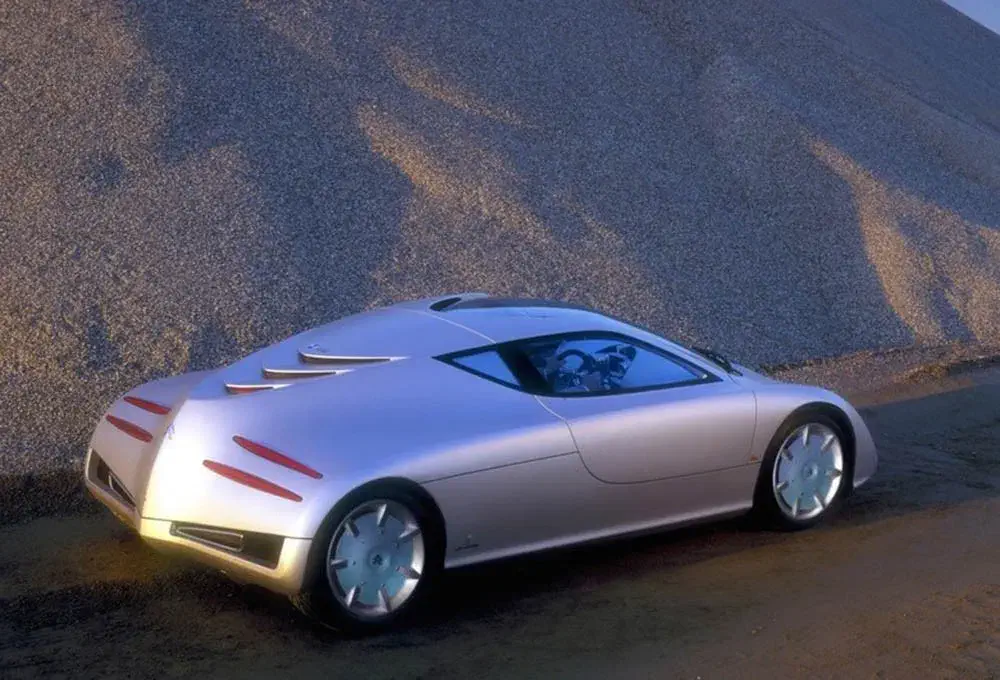 Futuristisch Maserati coupé prototype met strak ontwerp, geparkeerd voor een grindhoop.
