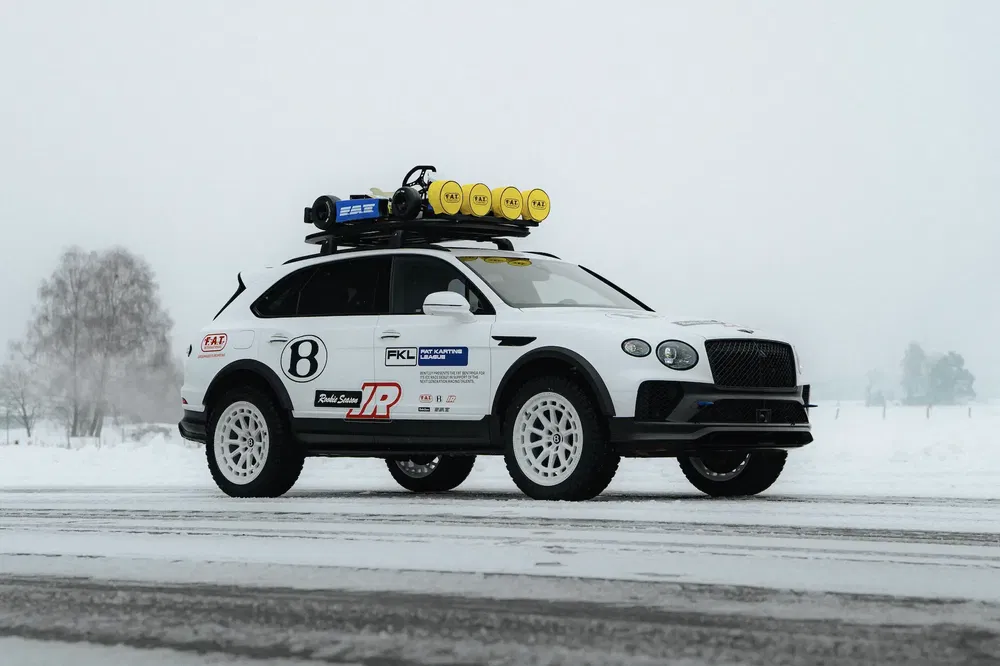 Bentley Bentayga rally op sneeuw met daklampen en terreinbanden.