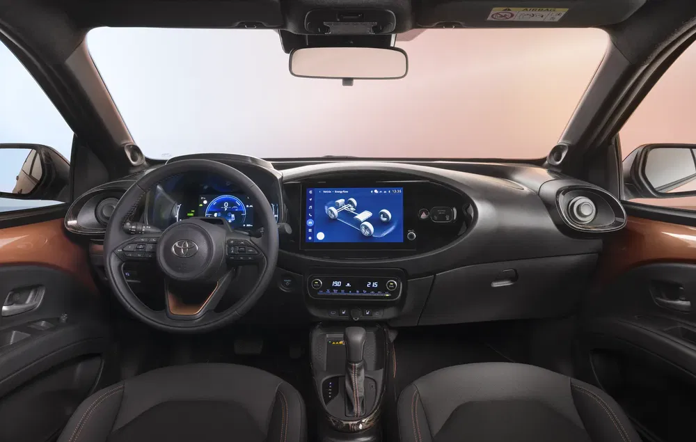 Moderne interieur van Toyota met centrale touchscreen, multifunctioneel stuur en lederen stoelen.