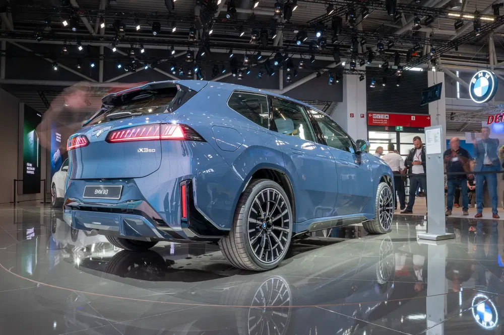 {"fr":"BMW iX3 bleu exposé dans un salon automobile avec éclairage moderne.","nl":"Blauwe BMW iX3 tentoongesteld in een autoshow met moderne verlichting."}
