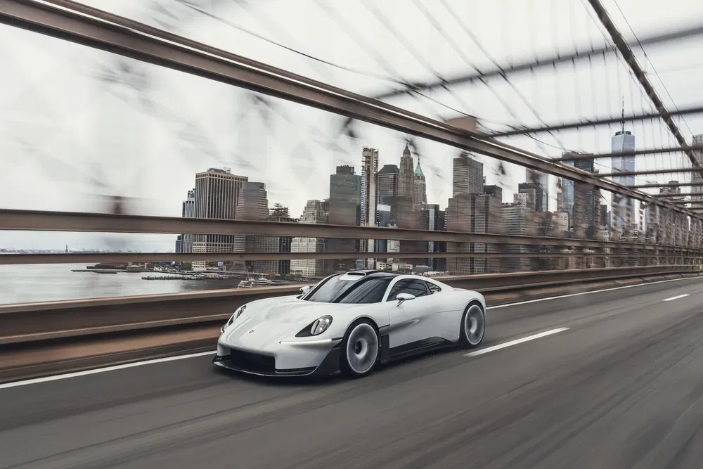 {"fr":"Voiture de sport Porsche blanc roulant sur un pont avec la skyline de New York en arrière-plan.","nl":"Witte Porsche sportwagen rijdt over brug met skyline van New York op de achtergrond."}