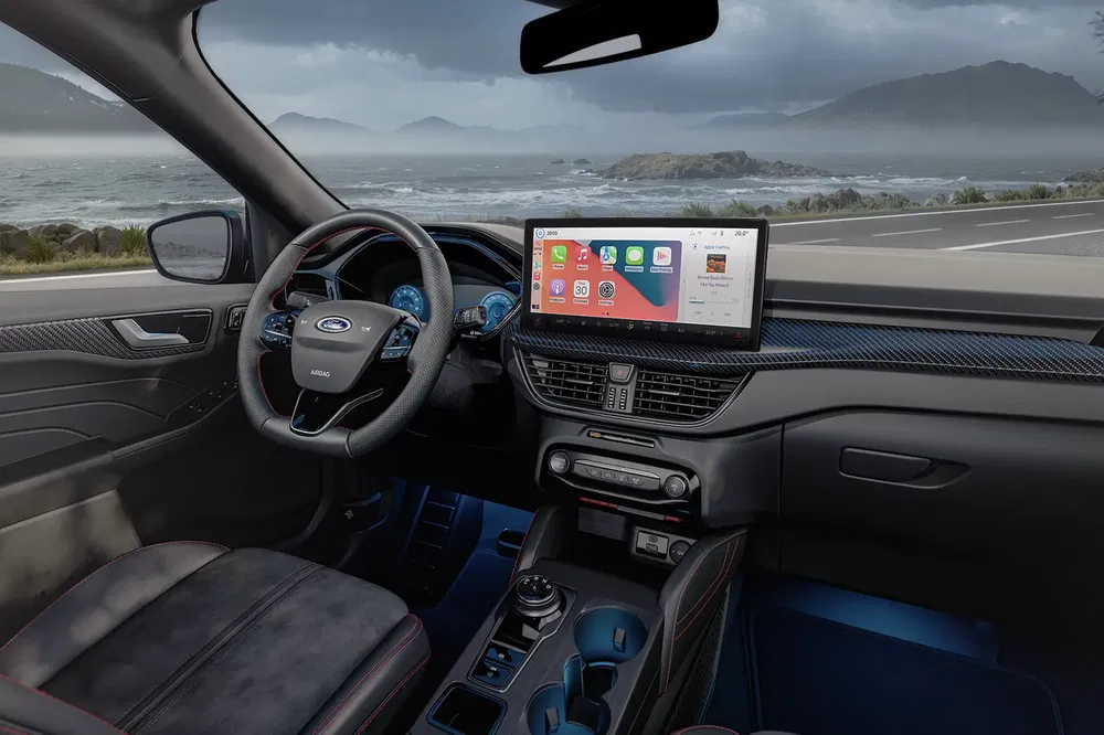 Moderne Ford-interieur met groot touchscreen en uitzicht op de zee.