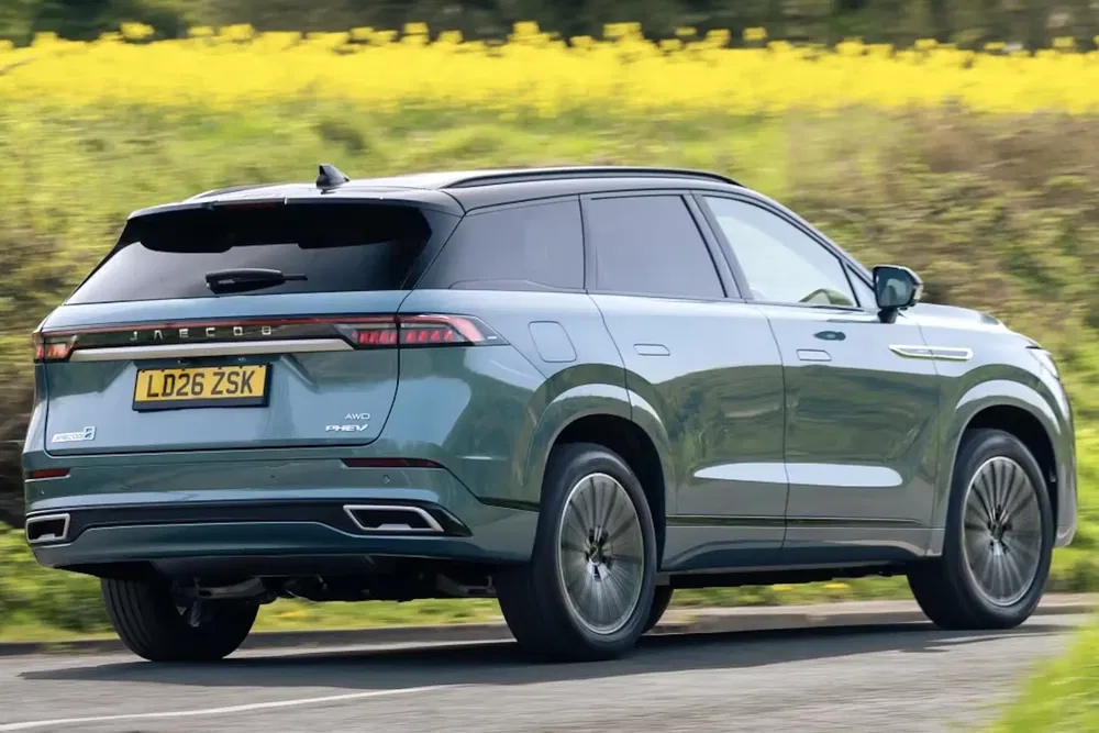 SUV Lync & Co 08 hybride vert en mouvement sur une route de campagne.