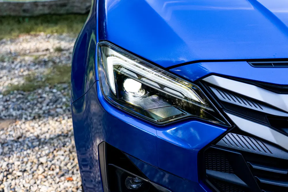 Phare avant d'une voiture bleue avec design moderne et élégance.