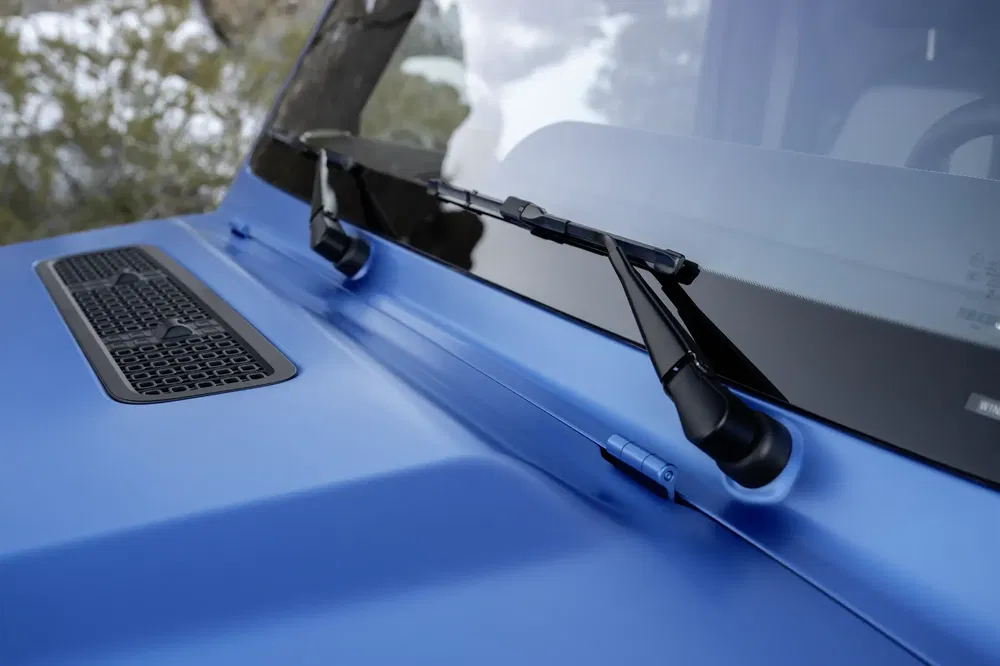 Essuie-glaces sur pare-brise de Jeep avec peinture bleue métallique, en gros plan.