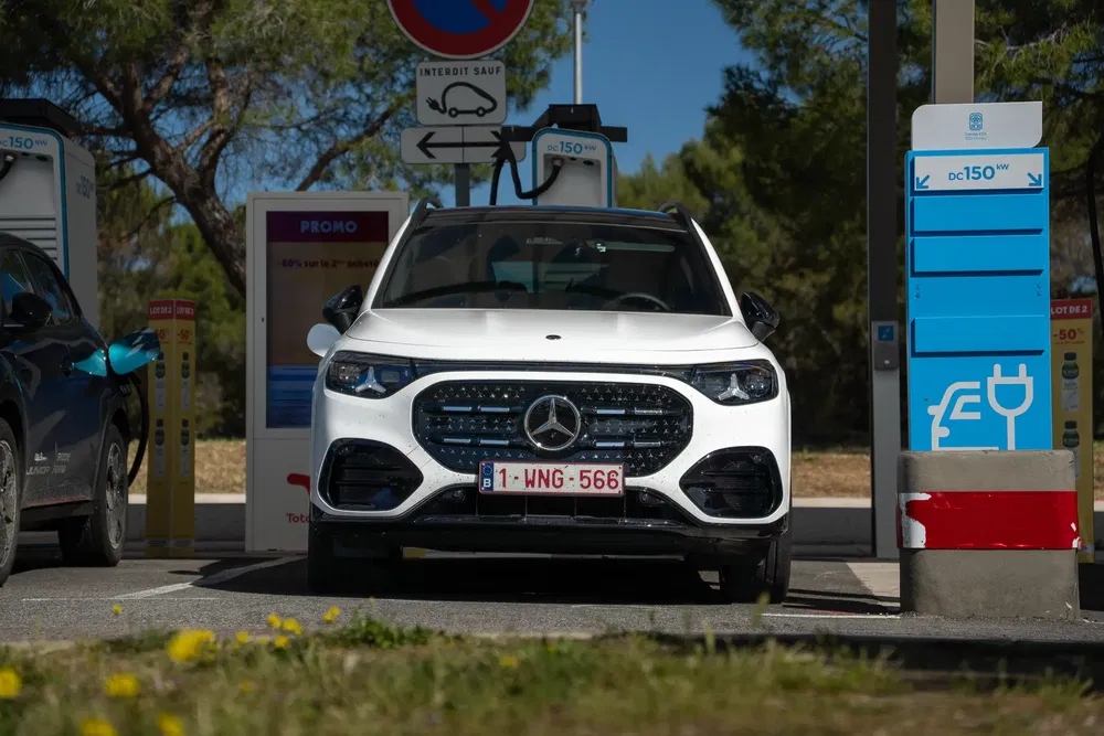 Mercedes EQB blanche en charge à une station électrique sous un ciel bleu.