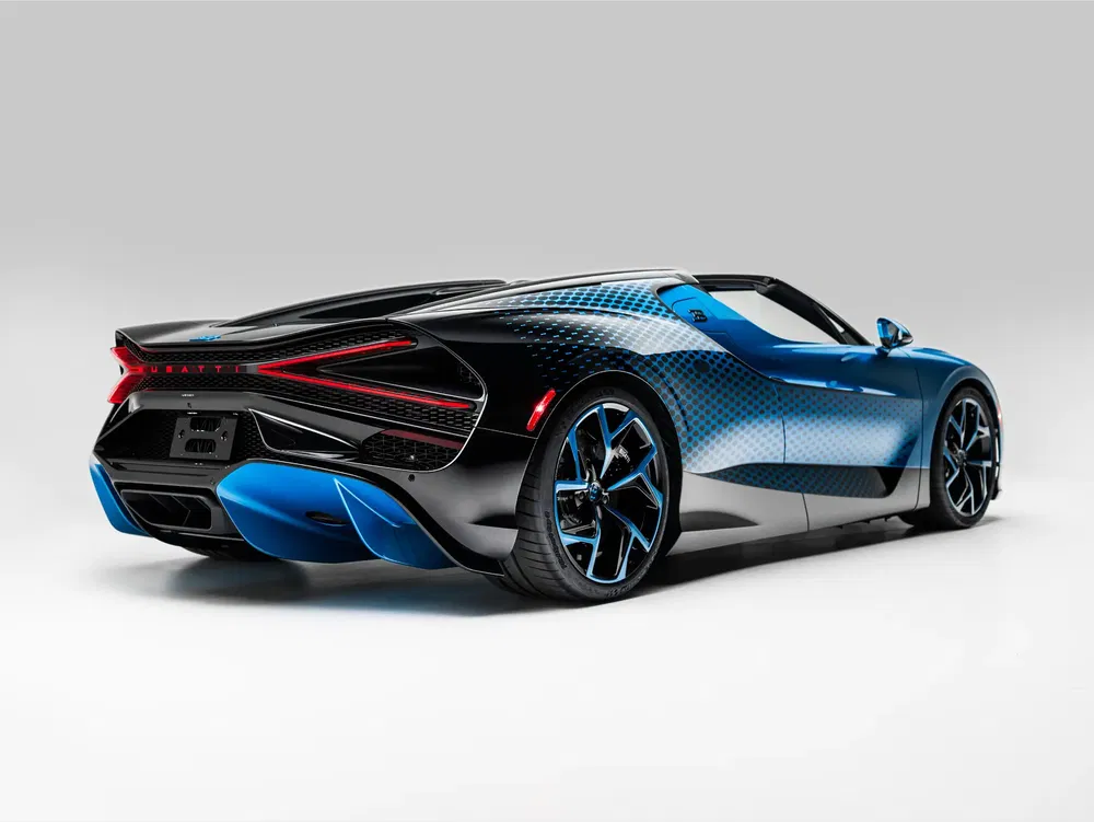 Hypercar Bugatti à la carrosserie noire et bleue élégante, vue arrière dynamique.