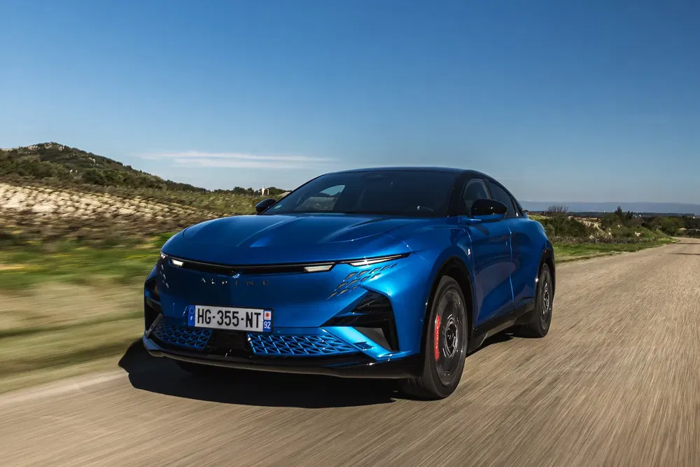 {"fr":"Peugeot 408 bleu roulant sur une route de campagne ensoleillée.","nl":"Blauwe Peugeot 408 rijdend op een zonnige plattelandsweg."}