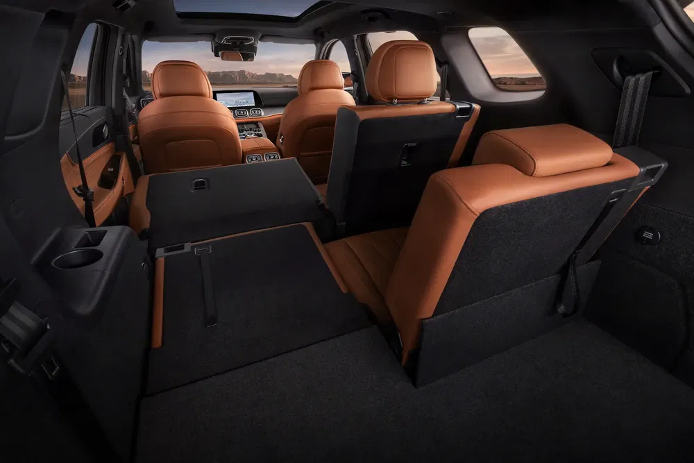 Intérieur d'un SUV avec sièges rabattables en cuir brun et espace de coffre spacieux.