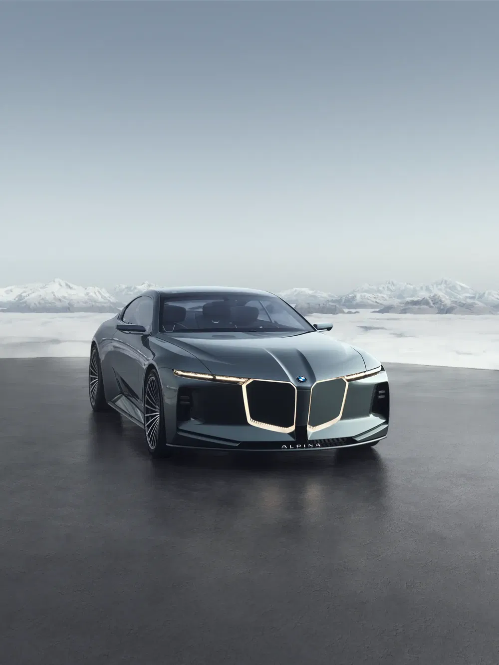 BMW Alpina élégante à l'avant montagneux sous un ciel clair et lumineux.