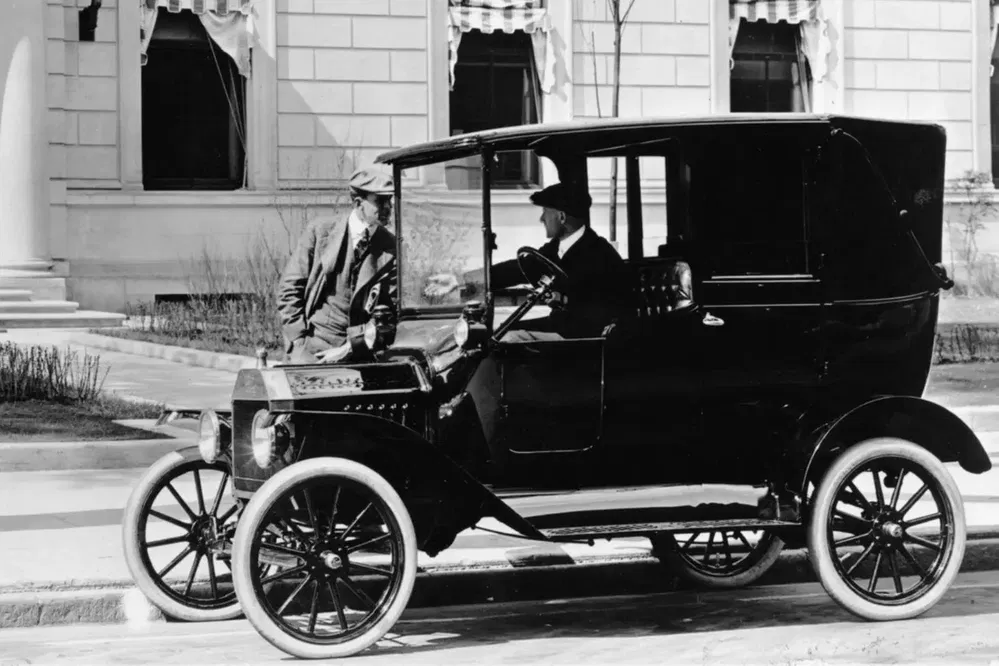 Une Ford Model T classique des années 1920 garée devant un bâtiment historique.
