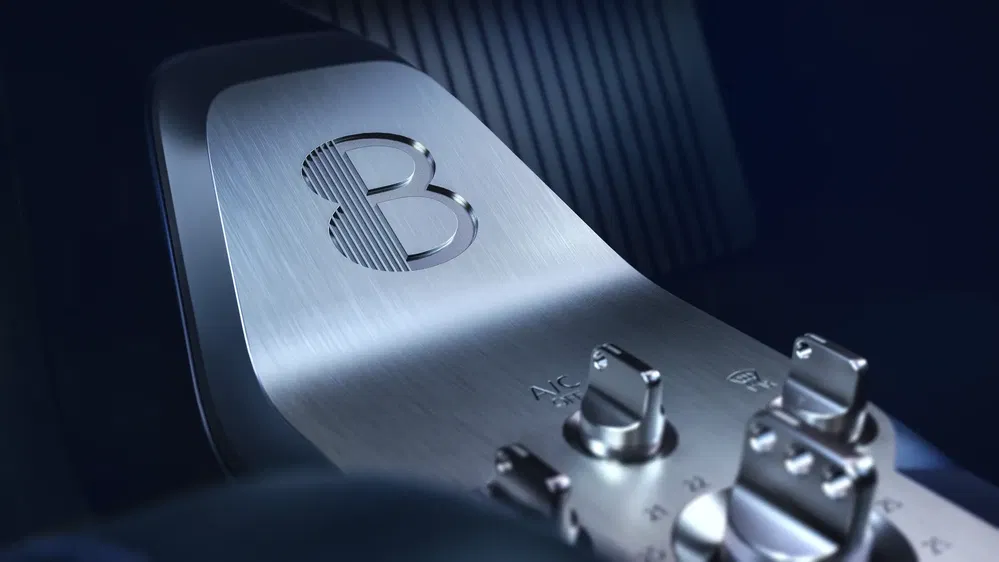 Intérieur luxueux d'une Bugatti avec logo emblématique en métal brossé et commandes élégantes.