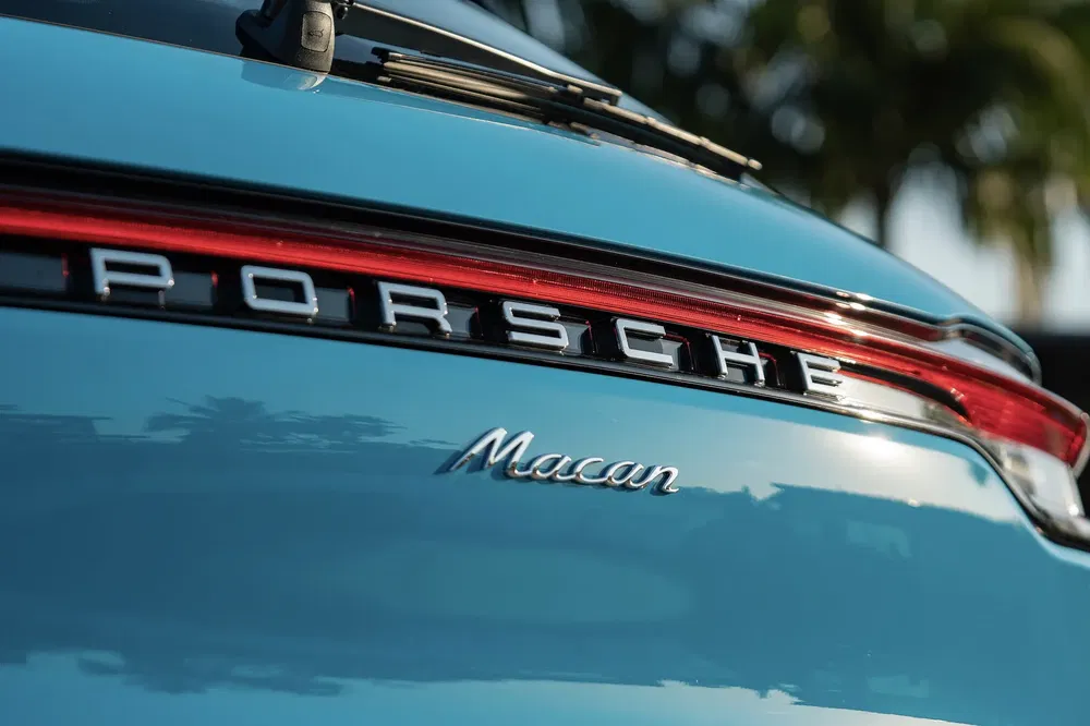 {"fr":"Arrière de Porsche Macan bleu avec badge et feu arrière distinctifs au design élégant.","nl":"Achterkant van blauwe Porsche Macan met kenmerkende badge en elegante achterlamp."}