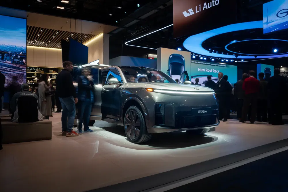 VUS Li Auto L9 exposé à un salon de l'automobile avec éclairage moderne et public attentif.