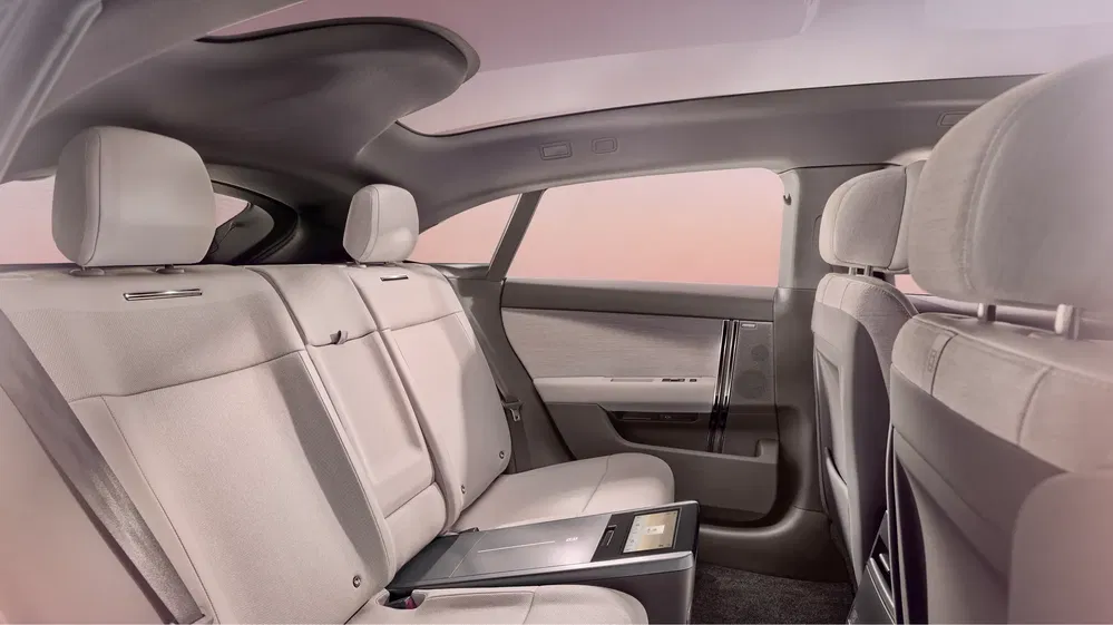 Intérieur luxueux avec sièges arrière en cuir beige et espace confortable dans une voiture moderne.