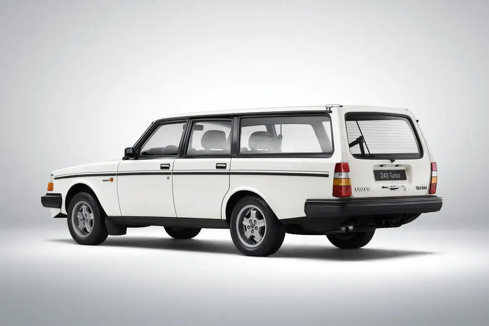 Break Volvo 240 Turbo blanc des années 80, vue arrière sur fond gris minimaliste.