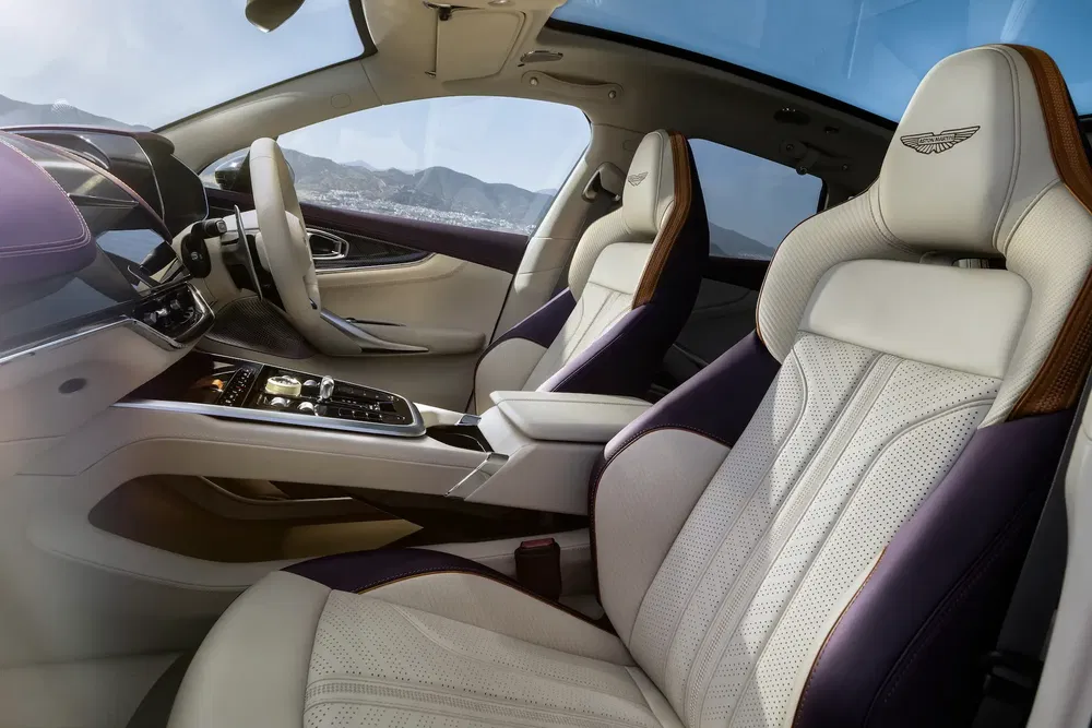 Intérieur luxueux d'une Aston Martin avec sièges en cuir perforé et tableau de bord moderne.