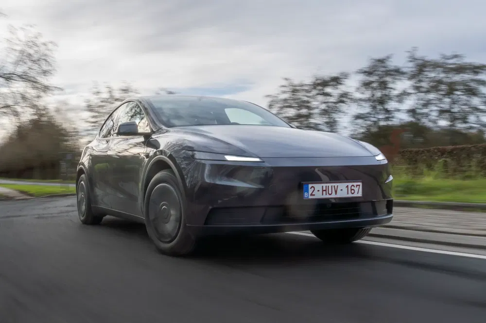 Innovatieve elektrische auto rijdt op een weg, met een aerodynamisch en modern ontwerp.