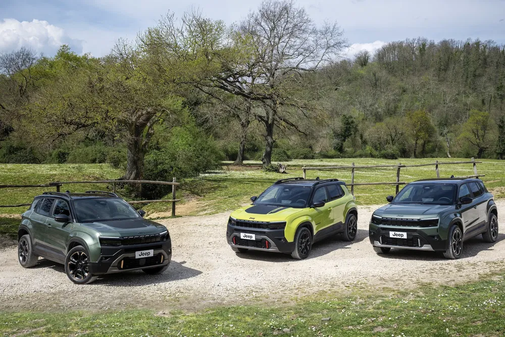 Trois Jeep Avenger 2023 dans un cadre naturel, différentes couleurs sous un ciel partiellement nuageux.