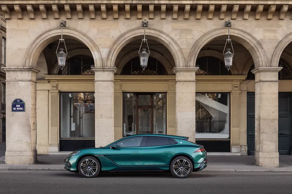 Voiture DS en vert émeraude stationnée devant une architecture classique à Paris.