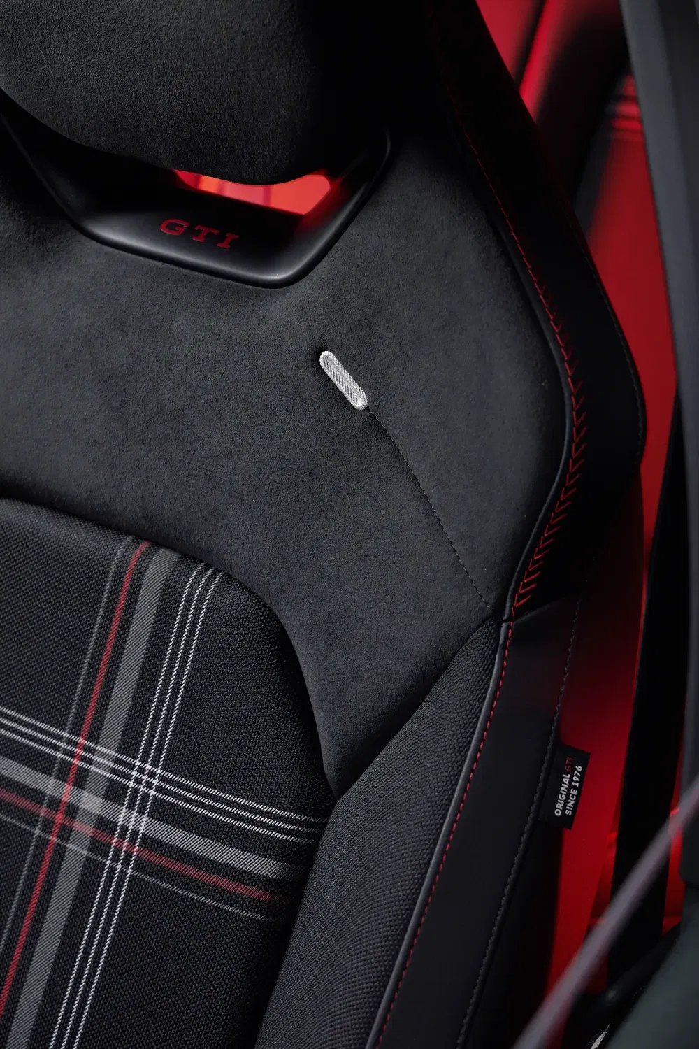 Siège sport Volkswagen Golf GTI avec tissu écossais et surpiqûres rouges distinctives.