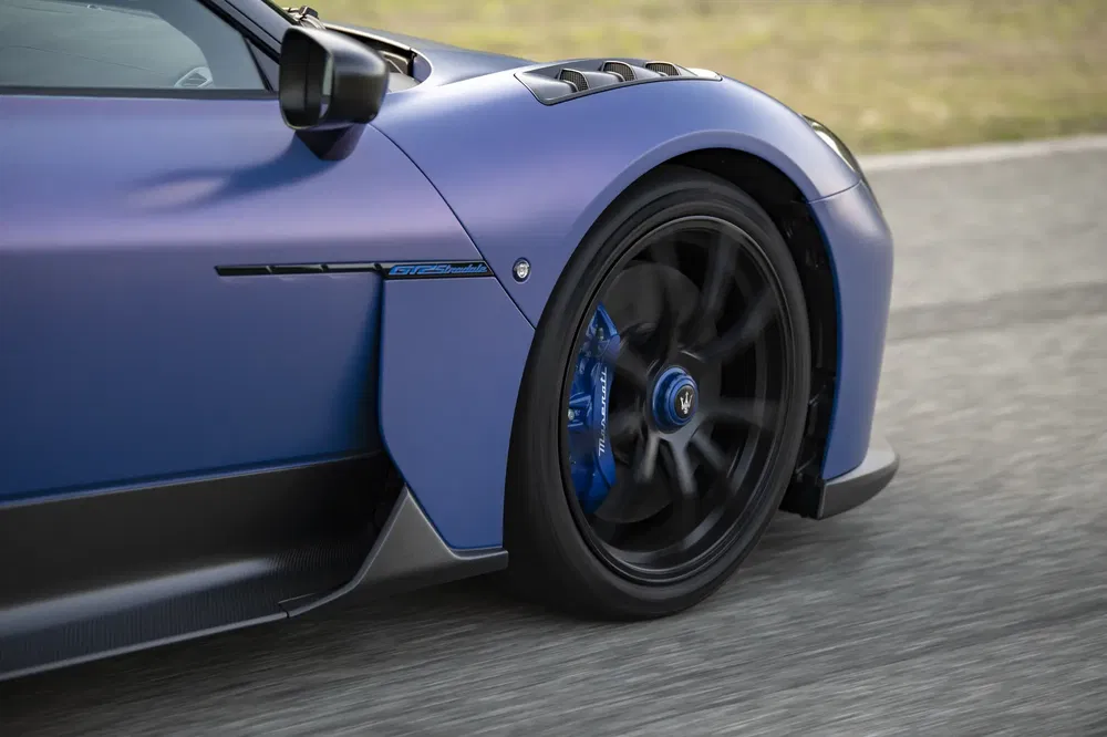 Gros plan de la roue avant d'une Maserati MC20 en course sur une piste.