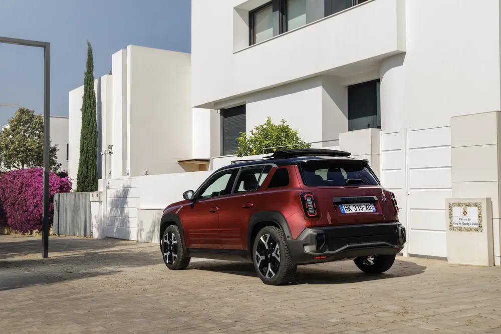 Mini Countryman rouge garée devant une maison moderne au style minimaliste.