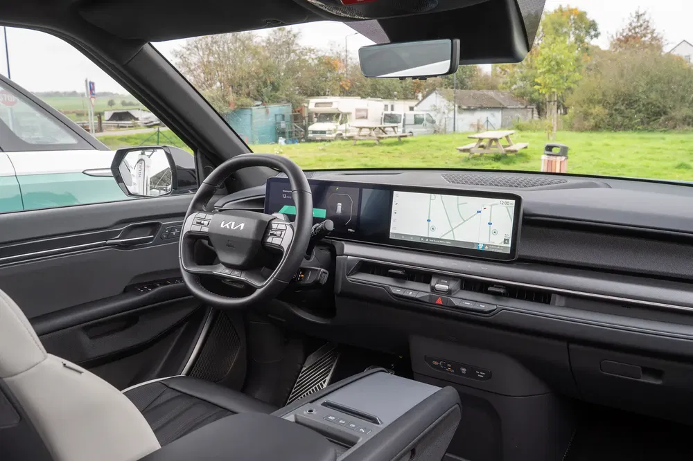 Intérieur moderne de Kia EV9 avec écran large de navigation et volant stylé.