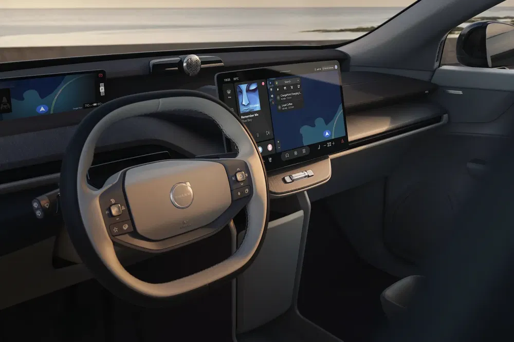 Intérieur Volvo avec tableau de bord numérique élégant et volant innovant en bord de mer.