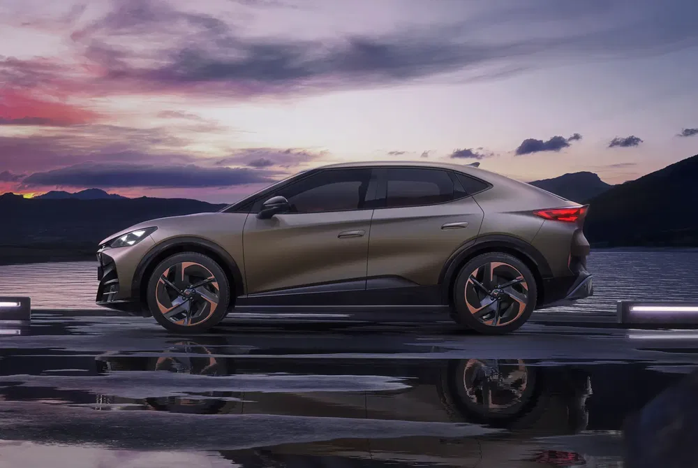 Cupra Tavascan électrique au bord d’un lac au coucher du soleil, design élégant et moderne.