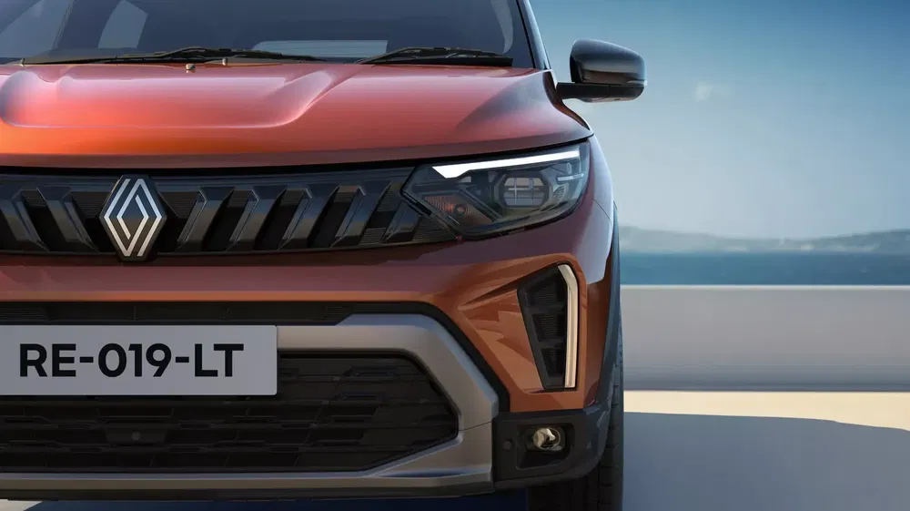 Demi-avant d'un SUV Renault rouge avec design moderne et phare LED distinctif.