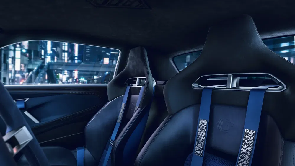 Intérieur de voiture de sport avec sièges en cuir bleu et ceintures de sécurité, vue urbaine nocturne.