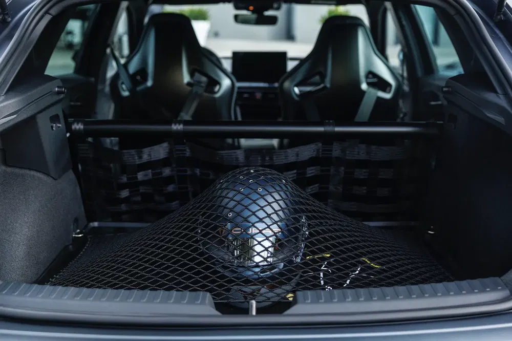 Kofferbak van een sportauto met beschermbeugel en veilig netopbergsysteem.