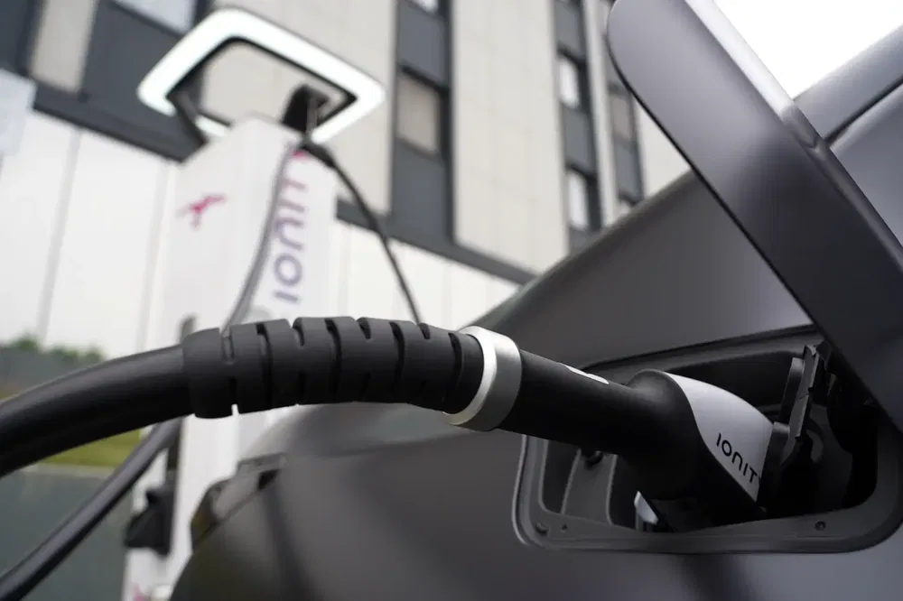 Voiture électrique en charge avec bornes Ionity modernes en arrière-plan.