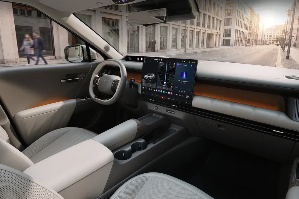 Intérieur moderne d'un véhicule électrique Rivian R1S avec grand écran tactile et finitions élégantes.